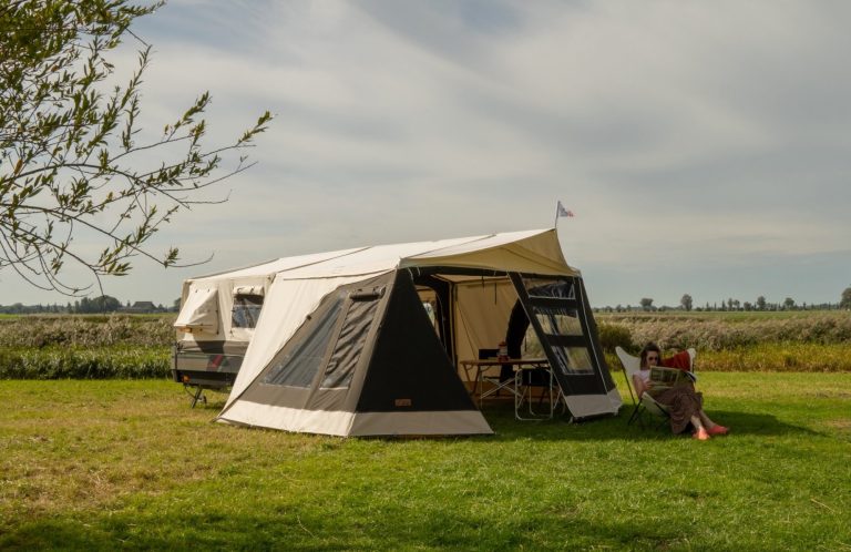 Combi-Camp-Zeltanhänger mit aufgebautem Vorzelt auf einer Wiese